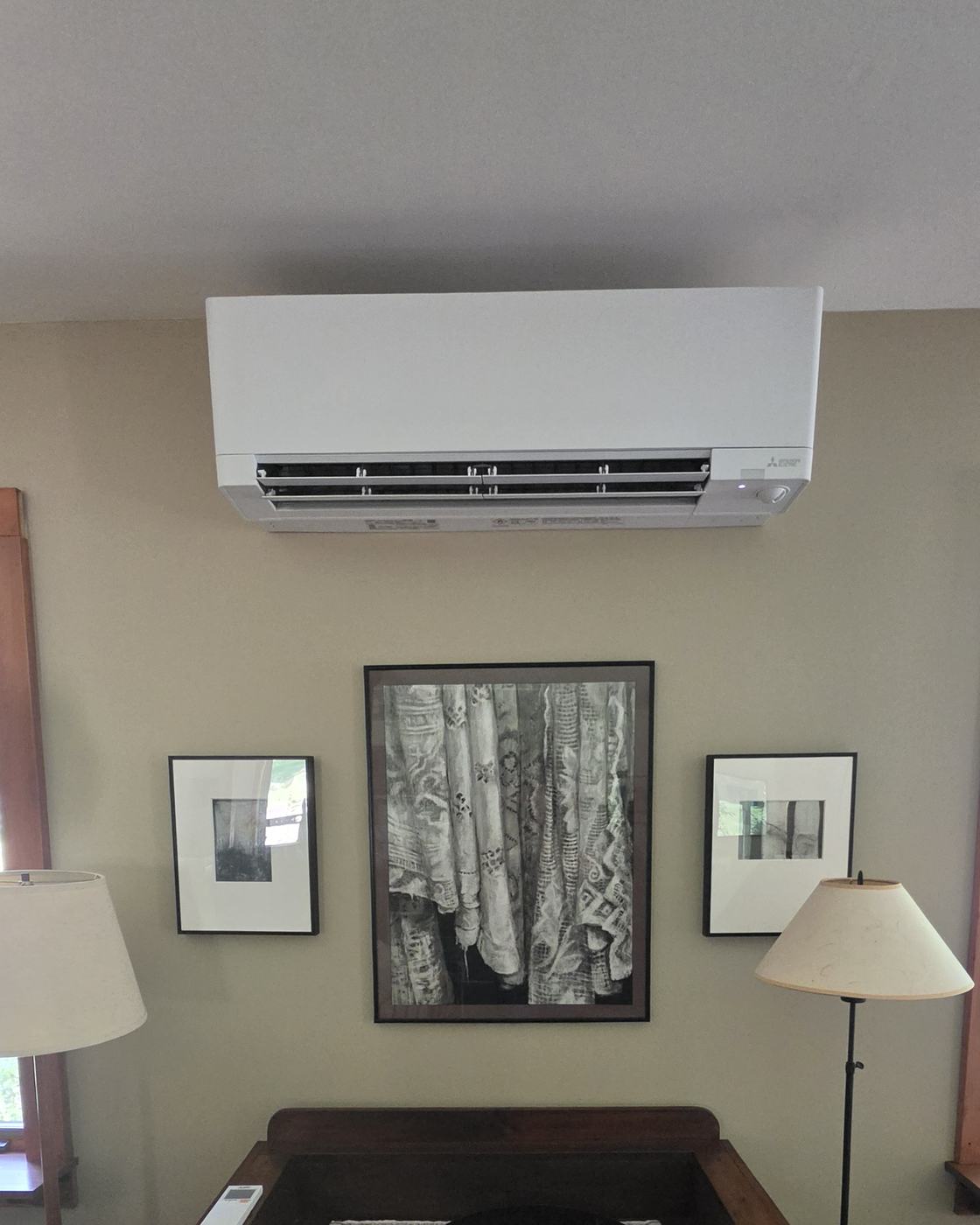 Mitsubishi wall-mounted heat pump above an antique dry sink in a Saratoga-area living room — installed by Superior CO-OP HVAC